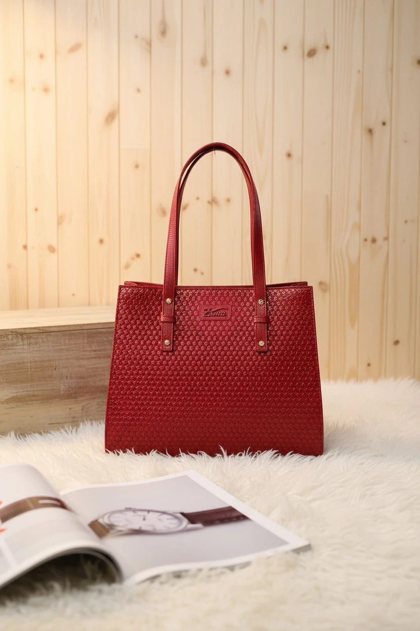 Bolso tote Moncayo Store de cuero rojo con textura geométrica, asas cortas y detalles en herrajes dorados.