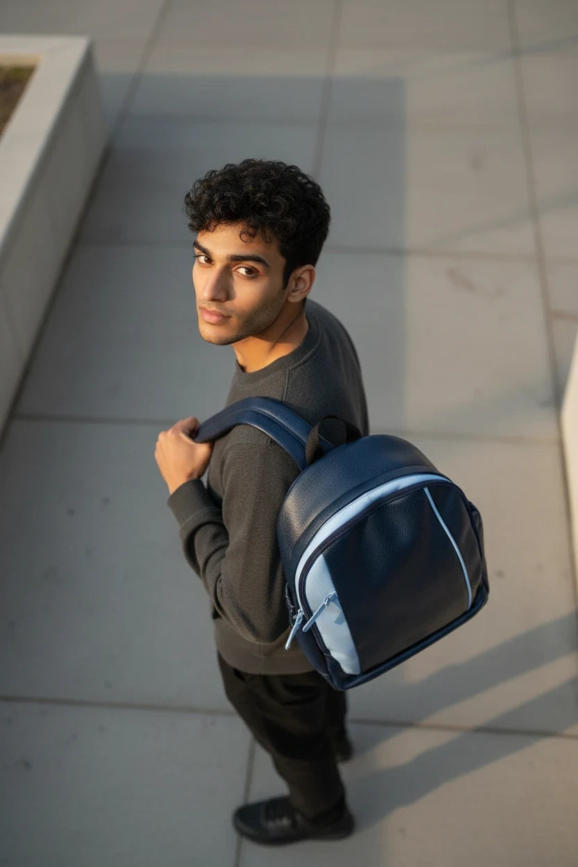 Joven con mochila de cuero natural Moncayo Store en color navy con detalles en azul cielo y tiras ajustables